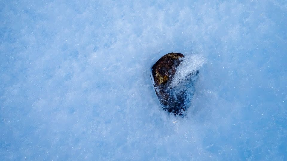 Σε αντίθεση με τα περισσότερα δείγματα που συλλέγονται στην επιφάνεια, ένας μετεωρίτης βρίσκεται εν μέρει σε πάγο.  - Katherine Joy/University of Manchester/The Lost Meteorites of Antarctica Project