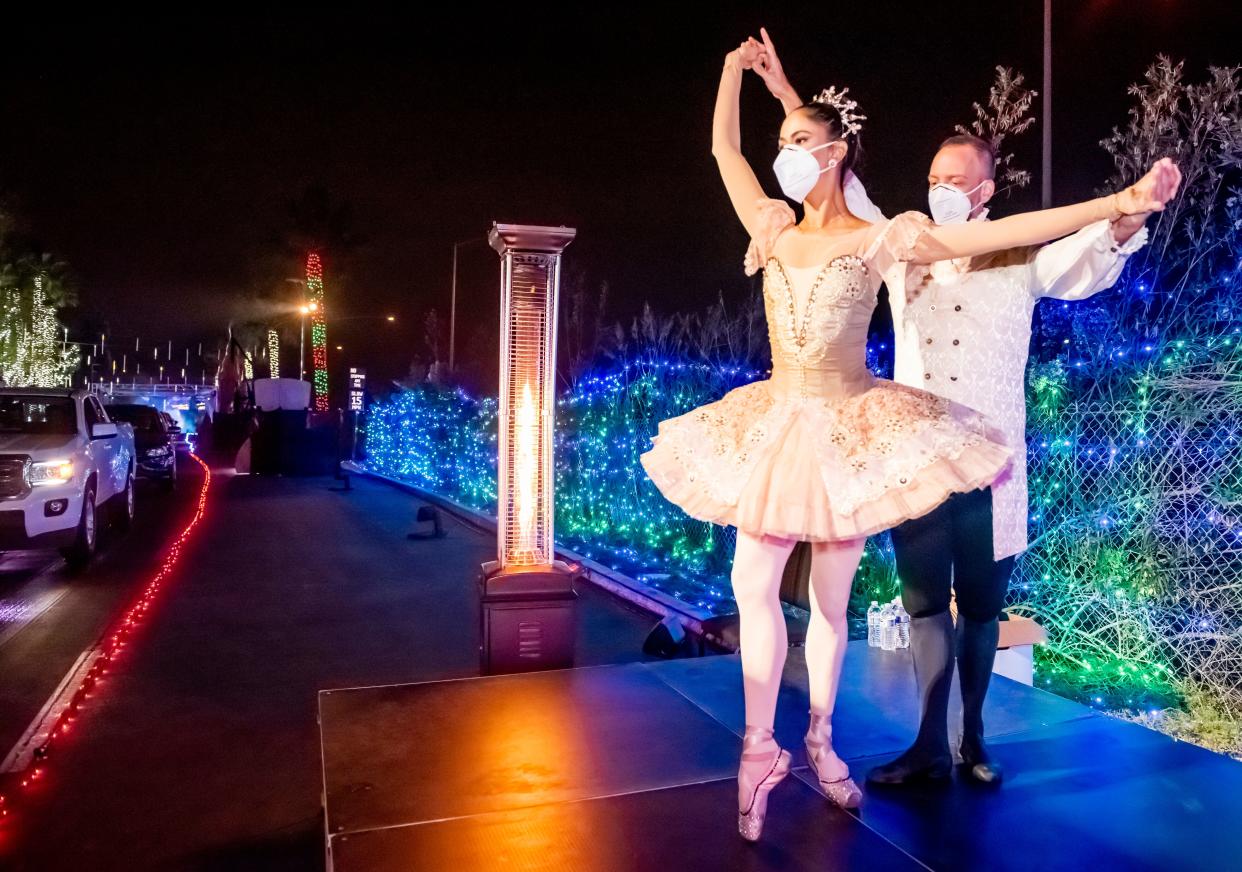 Dancers Susan Vishmid (left) and A.J. Abrams perform Dec. 13 for visitors touring the "Light of the World: Christmas Lights" drive-thru experience at Saddleback Church in Lake Forest, California. (Photo: Leonard Ortiz/Orange County Register via Getty Images)