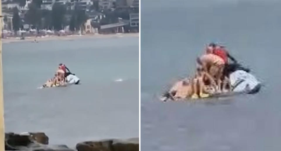 Swimmers pile onto the back of a jetski at Manly Beach after a shark alarm was sounded.