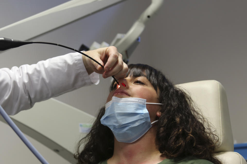 Gabriella Forgione, a 25-year-old patient, holds still as a doctor slides a miniature camera up her nose during tests in a hospital in Nice, France, on Monday, Feb. 8, 2021, to help determine why she has been unable to smell or taste since she contracted COVID-19 in November 2020. A year into the coronavirus pandemic, doctors and researchers are still striving to better understand and treat the accompanying epidemic of COVID-19-related anosmia — loss of smell — draining much of the joy of life from an increasing number of sensorially frustrated longer-term sufferers like Forgione. (AP Photo/John Leicester)