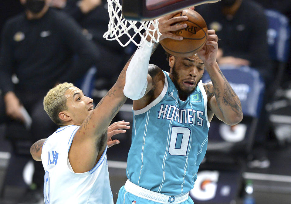 Charlotte Hornets forward Miles Bridges, right, gains control of a rebound against Los Angeles Lakers forward Kyle Kuzma, left, during the first half of an NBA basketball game in Charlotte, N.C., Tuesday, April 13, 2021. (Jeff Siner/The Charlotte Observer via AP)