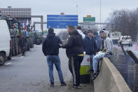 Farmers gather on a blocked highway, Thursday, Feb.1, 2024 in Argenteuil, north of Paris. France's two major farmers unions announced Thursday their decision to suspend protests and lift road blockades across the country, in a dramatic development shortly after the French prime minister unveiled a new set of measures they see as "tangible progress." Farmers have been protesting for days across the country to denounce low wages, heavy regulation and unfair competition from abroad. (AP Photo/Michel Euler)