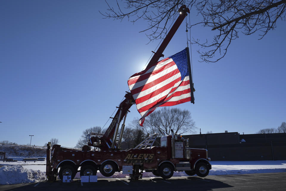 A firetruck with a flag at half mast sits outside Burnsville City Hall after two police officers and a first responder were shot and killed Sunday, Feb. 18, 2024, in Burnsville, Minn. (AP Photo/Abbie Parr)