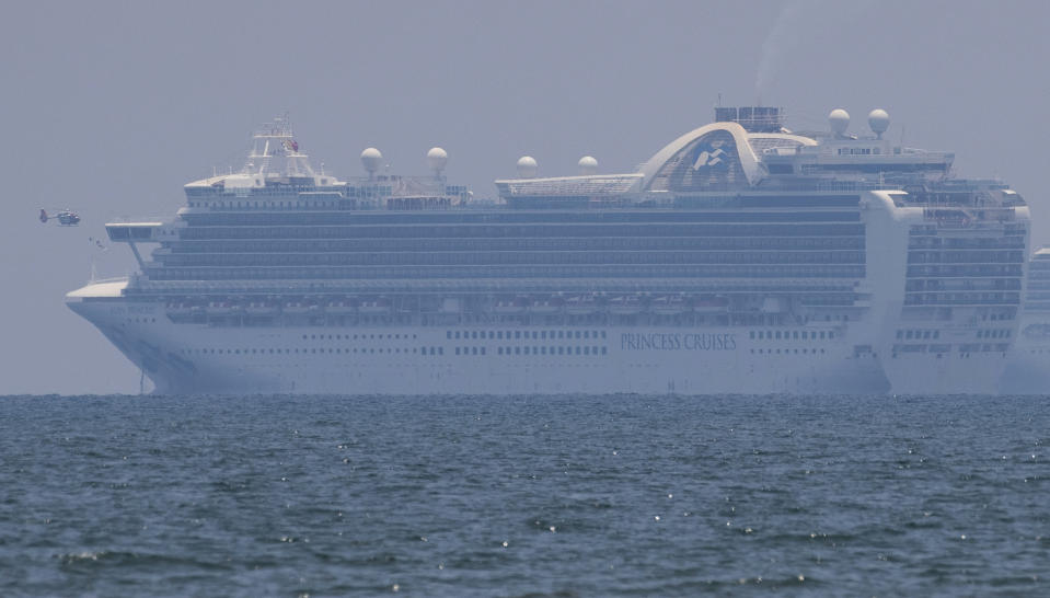 A Philippine government helicopter flies beside the cruise ship Ruby Princess as it is anchored off Manila Bay, Philippines, Thursday, May 7, 2020. The Ruby Princess which is being investigated in Australia for sparking coronavirus infections, has sailed into Philippine waters to bring Filipino crewmen home. (AP Photo/Aaron Favila)