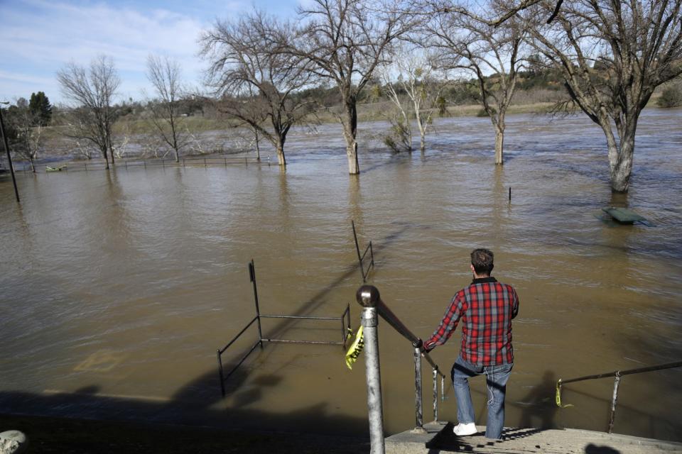 Rob McMillan, a television reporter from Los Angeles, reports from the overflowing Feather River Tuesday, Feb. 14, 2017, in Oroville, Calif. (Photo: Marcio Jose Sanchez/<br>AP)