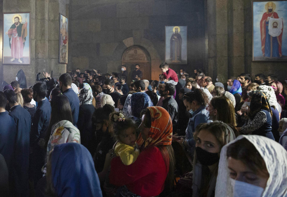 People attend a nationwide prayer for peace lead by Catholicos Karekin II in the Saint Gayane Church in Yerevan, Armenia, Saturday, Oct. 3, 2020. Armenia and Azerbaijan say heavy fighting is continuing in their conflict over the separatist territory of Nagorno-Karabakh and Azerbaijan's president said late Saturday that his troops had taken a village.(Grigor Yepremyan/PAN Photo via AP)