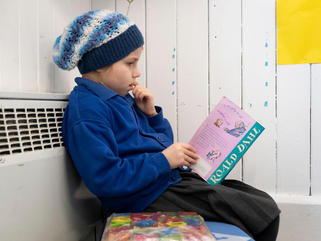 A child reads a Roald Dahl book at a primary school.