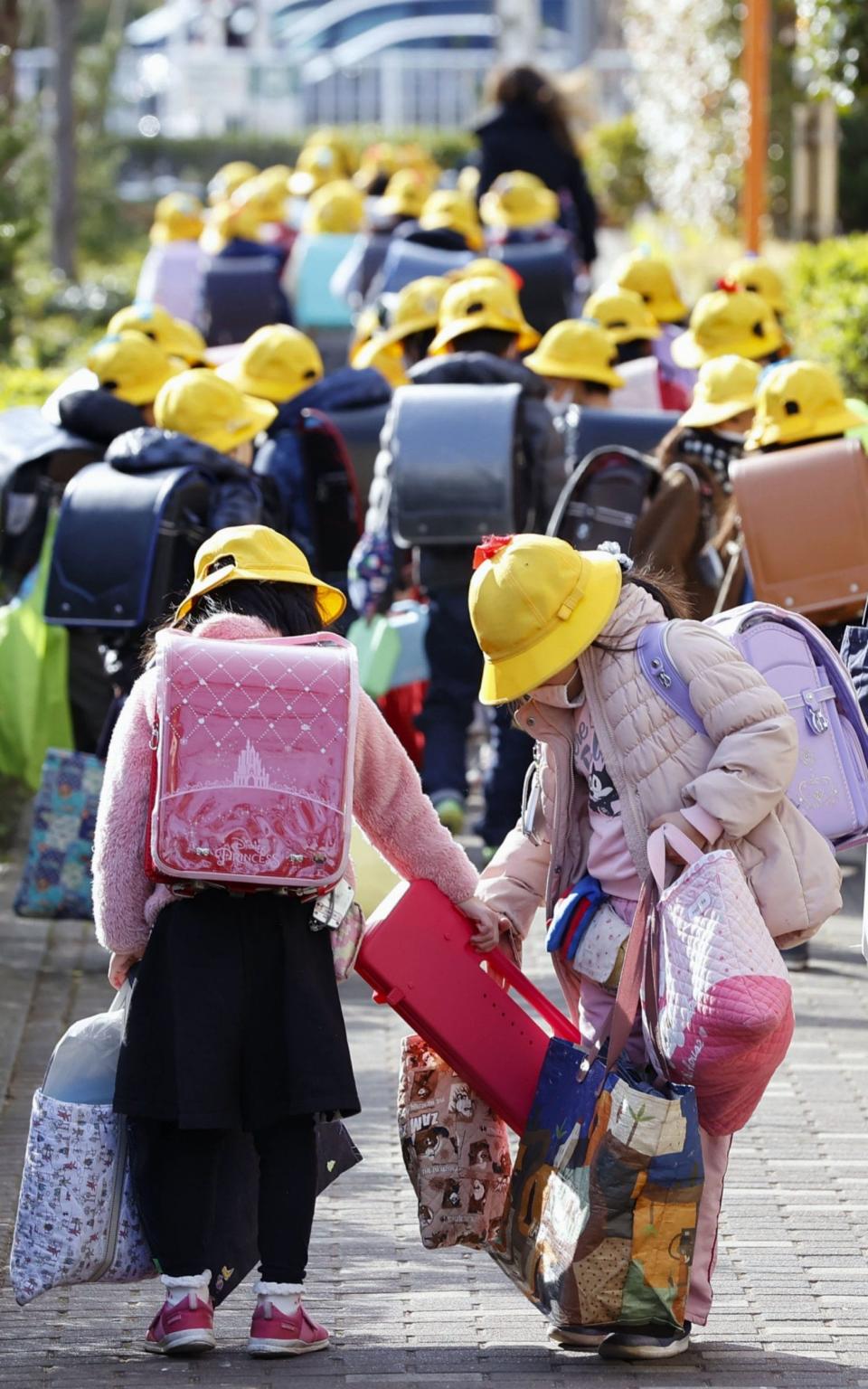 Pupils leave an elementary school in Tokyo, which was abruptly declared the last day of the school year after Prime Minister Shinzo Abe announced the government would request all schools in Japan to close - B434