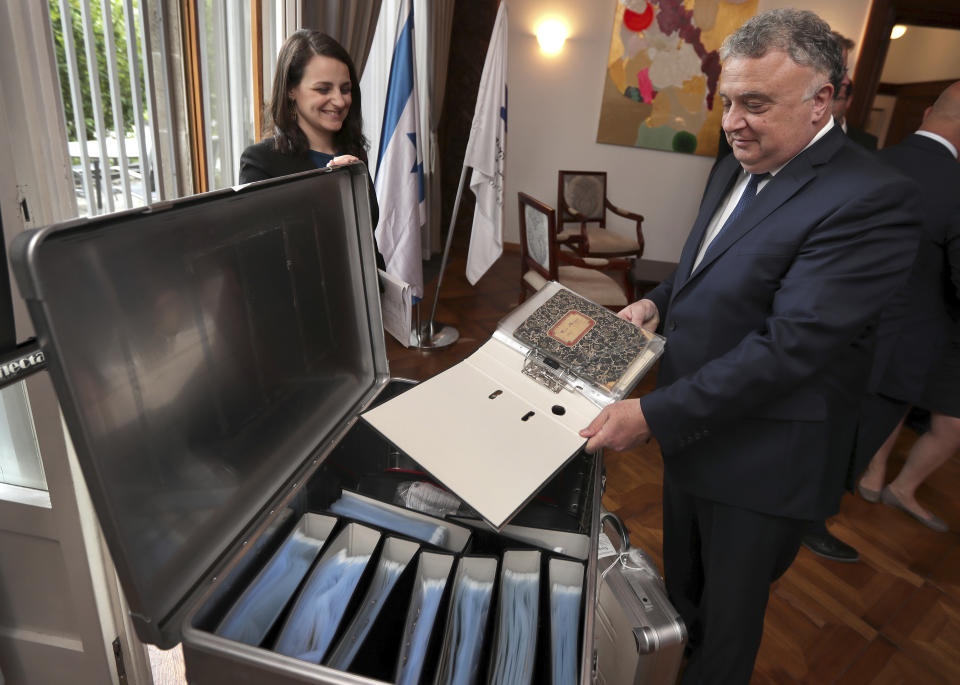 Israel's ambassador in Germany, Jeremy Issacharoff, right, holds documents prior to a handing over ceremony at the embassy of Israel in Berlin, Germany, Tuesday, May 21, 2019. German authorities are handing over to Israel some 5,000 documents kept by a confidant of Franz Kafka, a trove whose plight could have been plucked from one of the author's surreal stories. (AP Photo/Michael Sohn)