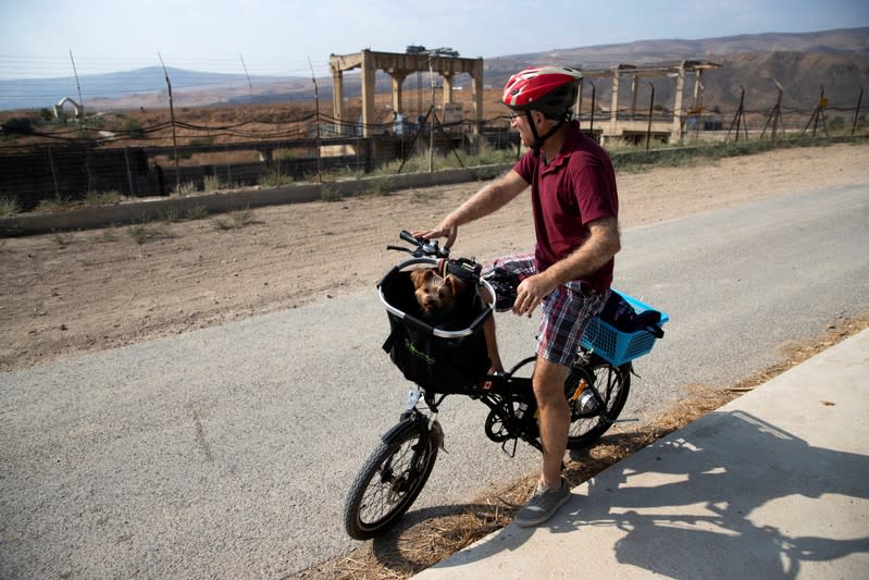 A cyclist looks on at the border area between Israel and Jordan near Naharayim