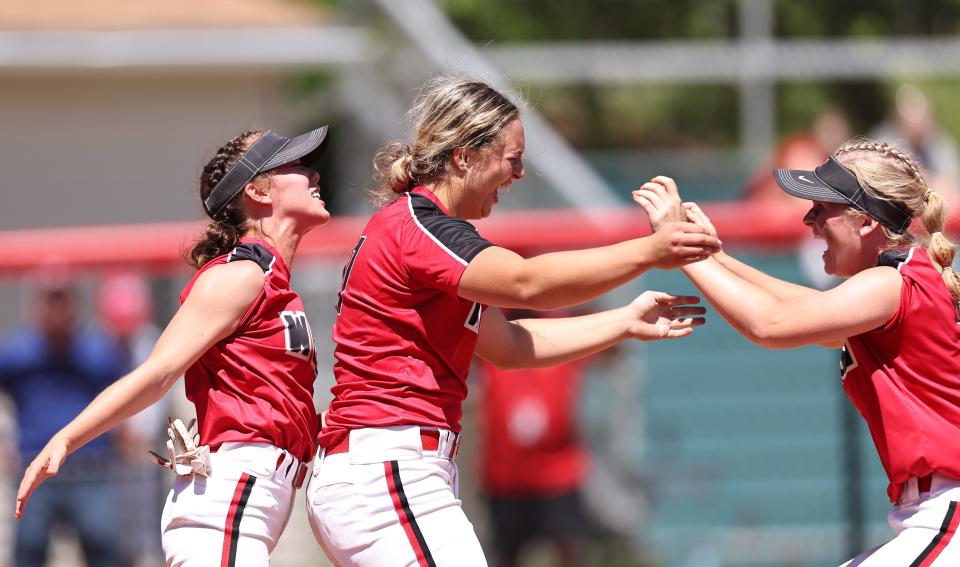 Lakota West pitcher K.K. Mathis, center, and teammates celebrate after the Firebirds won the Division I state softball championship at Firestone Park in Akron, Saturday, June 4, 2022.