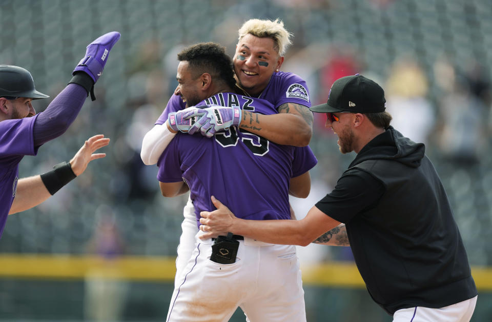 Colorado Rockies' Elias Diaz, center front, is congratulated after he drove in the tying and winning runs against the Chicago White Sox in the ninth inning of a baseball game Wednesday, July 27, 2022, in Denver. From left are Brendan Rodgers, Yonathan Daza and Kyle Freeland. (AP Photo/David Zalubowski)