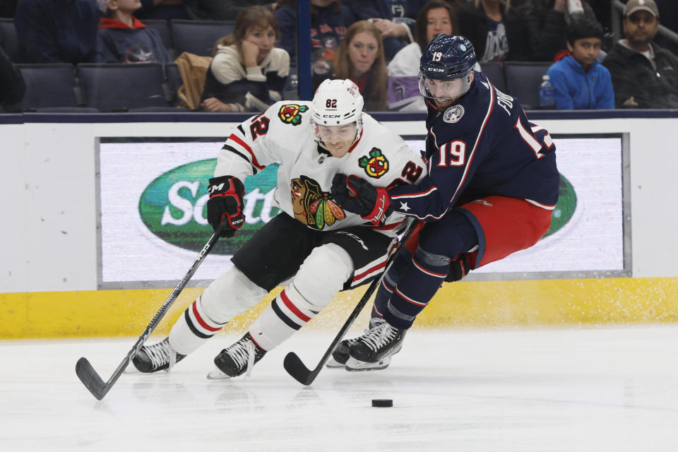 Chicago Blackhawks' Caleb Jones, left, and Columbus Blue Jackets' Liam Foudy skate after a loose puck during the second period of an NHL hockey game on Saturday, Dec. 31, 2022, in Columbus, Ohio. (AP Photo/Jay LaPrete)