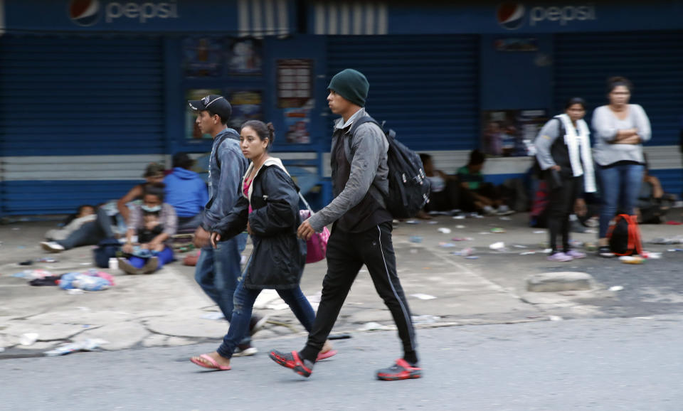 Migrants walk and rest in Puerto Barrios, Guatemala, after crossing the border from Honduras, Friday, Oct. 2, 2020. Guatemala vowed to detain and return members of a new caravan of about 2,000 migrants that set out from neighboring Honduras in hopes of reaching the United States, saying they represent a health threat amid the coronavirus pandemic. (AP Photo/Moises Castillo)