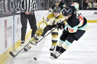 Vegas Golden Knights center William Karlsson (71) and Seattle Kraken defenseman Ryker Evans (39) battle for the puck during the second period of an NHL hockey game Thursday, March 21, 2024, in Las Vegas. (AP Photo/David Becker)