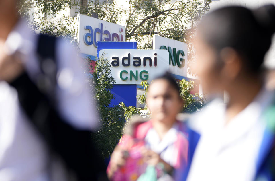 People walk past an Adani Compressed Natural Gas (CNG) station in Ahmedabad, India, Feb. 2, 2023. Shares in Adani Enterprises tumbled 26% Thursday, while stock in six other Adani companies fell 5%-10%. Adani slid from being the world’s third richest man to the 13th as his fortune sank to $72 billion, according to Bloomberg’s Billionaire Index. (AP Photo/Ajit Solanki)