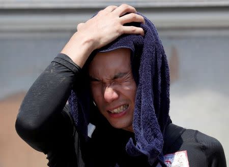 FILE PHOTO: A volunteer, for recovery work, wipes his sweat as he takes a break in a heat wave at a flood affected area in Kurashiki, Okayama Prefecture, Japan, July 14, 2018. REUTERS/Issei Kato/File Photo