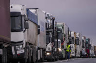 Trucks wait a blocked road in Corral de Almaguer, near Toledo, central Spain, Friday, Feb. 9, 2024. Thousands of Spanish farmers on tractors are blocking highways and some city streets in a fourth consecutive day of protest against European Union agriculture policies. (AP Photo/Manu Fernandez)