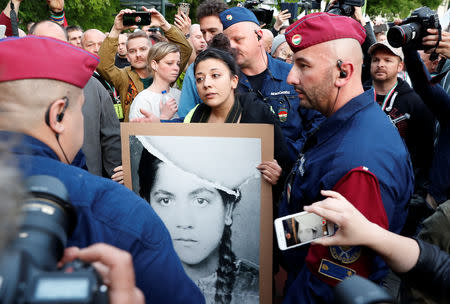 A counter-demonstrator holds a placard depicting Roma Holocaust victim as members of far-right, nationalist groups attend a protest against criminal attacks caused by youth, in Torokszentmiklos, Hungary, May 21, 2019. REUTERS/Bernadett Szabo