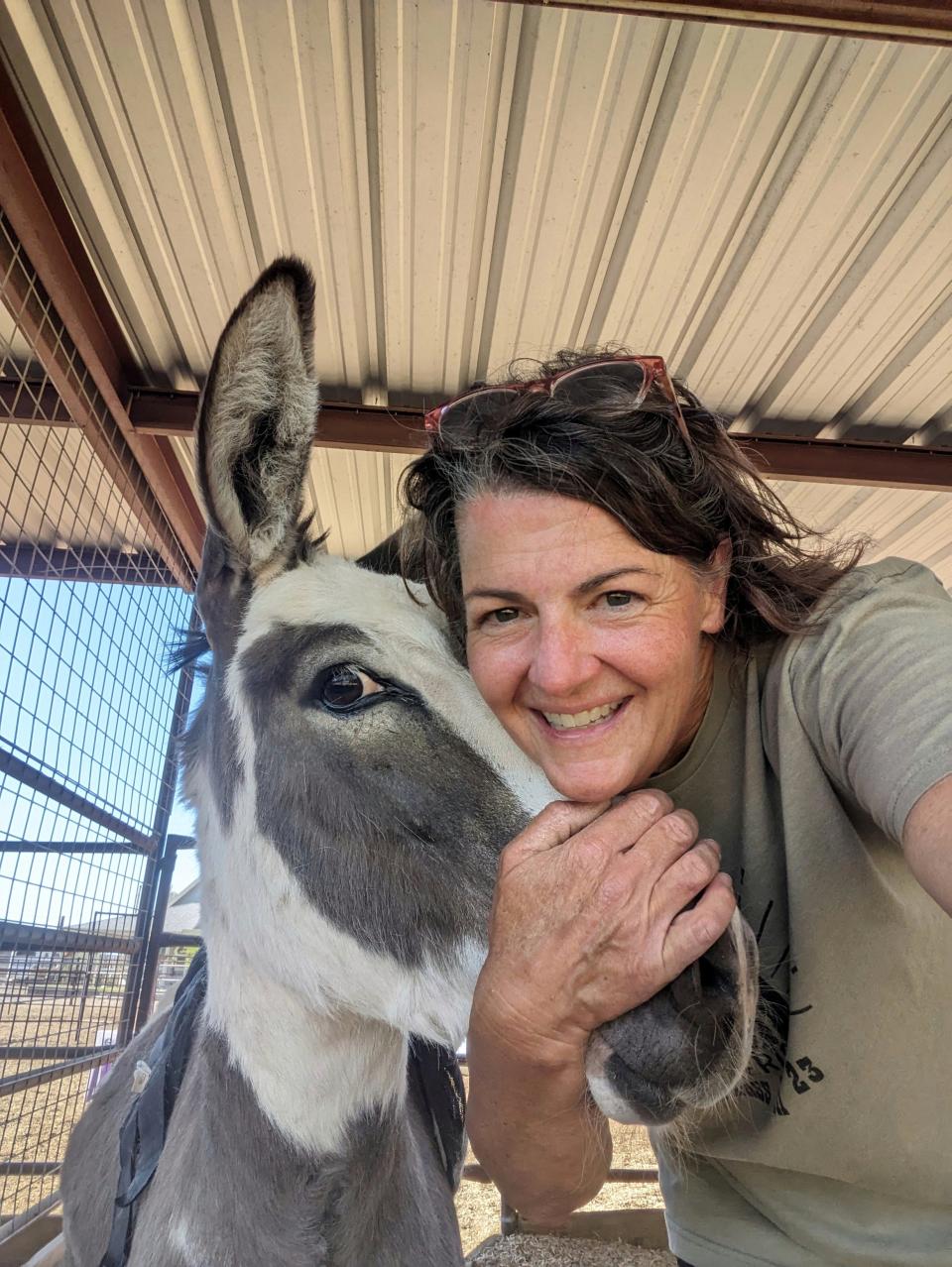 Alison McKee, owner of BTR Sourdough Bakery, poses with a photo with one of her donkeys.