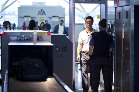 A traveler walks through a metal detector at a security check point in John F. Kennedy Airport in New York, February, 29, 2012. REUTERS/Andrew Burton