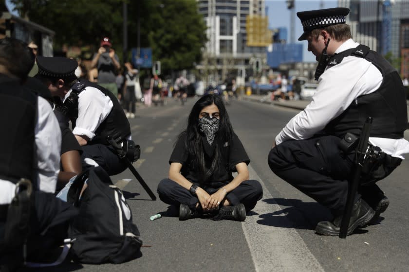 Police officers try to convince people to move from blocking the road outside the U.S. embassy after people marched there from Trafalgar Square in central London on Sunday, May 31, 2020, to protest against the recent killing of George Floyd by police officers in Minneapolis, USA, that has led to protests in many countries and across the U.S. (AP Photo/Matt Dunham)