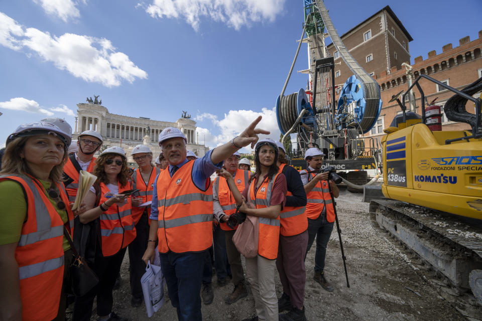 Chief engineer Andrea Sciotti, center, technical director for Rome's new 25.5-kilometer Metro C subway talks to international journalists at the construction site of line C main hub in central Rome, Thursday, May 23, 2024. During a tour Thursday of the construction site at Piazza Venezia, Sciotti said works on the nearly 3 billion euro project, considered one of the most complicated in the world, were running at pace to be completed by 2034. In the background the Unknown Soldier monument. (AP Photo/Domenico Stinellis)