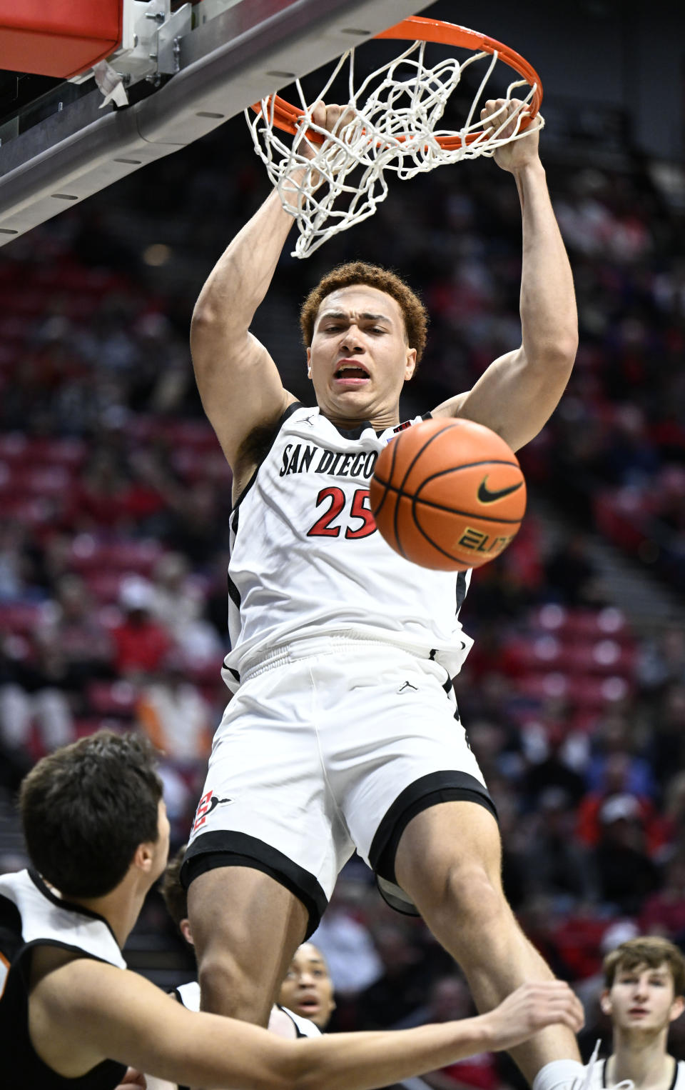 San Diego State forward Elijah Saunders (25) dunks over Occidental guard Nicky Clotfelter during the first half of an NCAA college basketball game Friday, Dec. 2, 2022, in San Diego. (AP Photo/Denis Poroy)