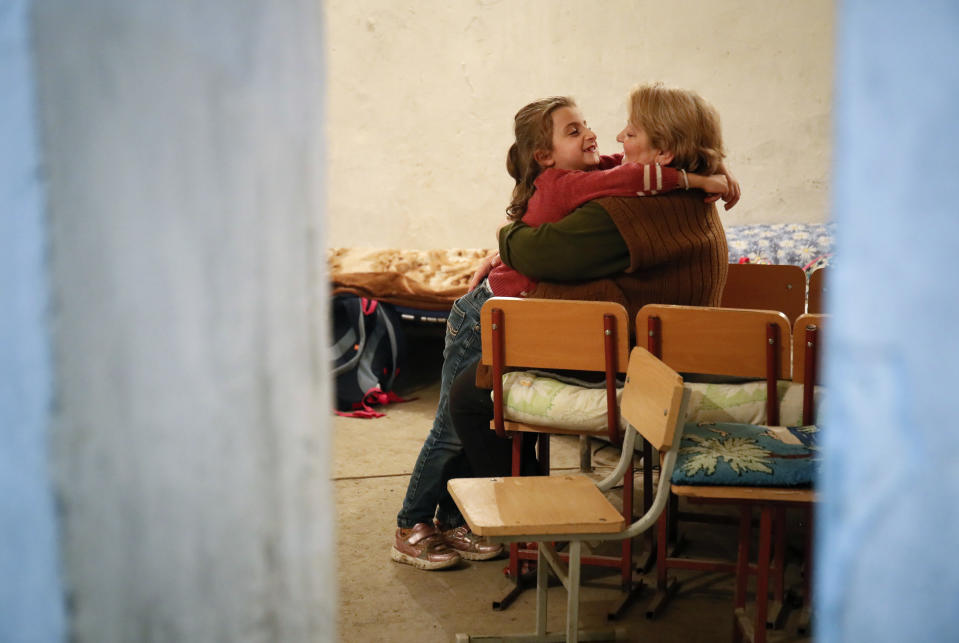 A girl hugs her grandmother as they take refuge in a bomb shelter in Stepanakert, the separatist region of Nagorno-Karabakh, Thursday, Oct. 22, 2020. Heavy fighting over Nagorno-Karabakh continued Thursday with Armenia and Azerbaijan trading blame for new attacks, hostilities that raised the threat of Turkey and Russia being drawn into the conflict. (AP Photo)