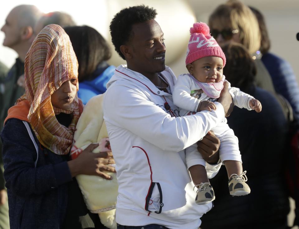 A family with a baby disembarks from an Italian military aircraft arriving from Misrata, Libya, at Pratica di Mare military airport, near Rome, Monday, April 29, 2019. Italy organized a humanitarian evacuation airlift for a group of 147 asylum seekers from Ethiopia, Eritrea, Somalia, Sudan and Syria. (AP Photo/Andrew Medichini)