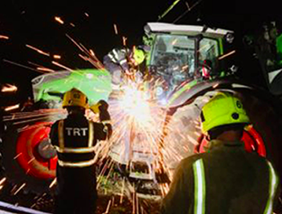 <em>Fire fighters get to work removing the tree and the tractor from the line (PA)</em>