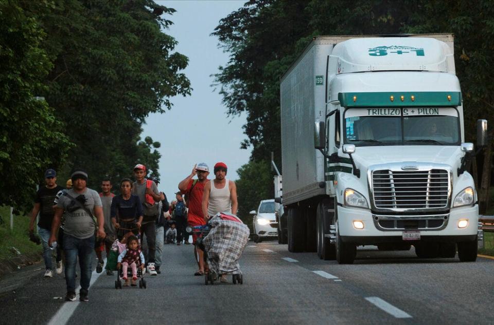 Migrants leave Ulapa, Chiapas state, late Saturday, Oct. 30, 2021. The migrant caravan heading north in southern Mexico has so far been allowed to walk unimpeded, a change from the Mexican government's reaction to other attempted mass migrations. (AP Photo/Isabel Mateos)