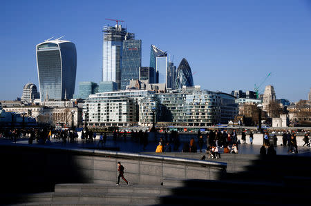 FILE PHOTO: The financial district can be seen as a person runs in the sunshine on London's south bank, Britain February 23, 2019. REUTERS/Henry Nicholls/File Photo