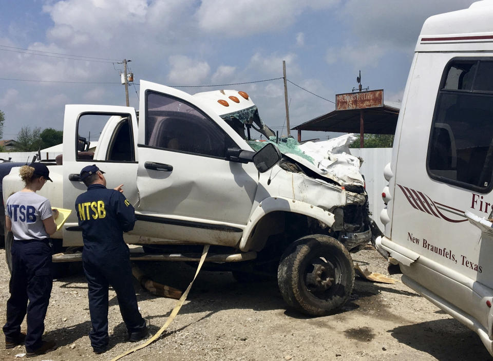 FILE - In this March 31, 2017 file photo provided by National Transportation Safety Board, Kristin Poland and David Pereira examine the pickup truck involved in a crash on March 29 on U.S. 83 near Garner State Park in Texas. The driver has been sentenced to 55 years in prison for causing the Texas church bus crash that killed 13 people. Twenty-one-year-old Jack Dillon Young of Leakey, Texas, was sentenced Friday, Nov. 9, 2018, after pleading no contest in June to 13 counts of intoxication manslaughter and one count of intoxication assault. He had faced up to 270 years in prison after a three-day sentencing hearing.(Jennifer Morrison/NTSB via AP, File)