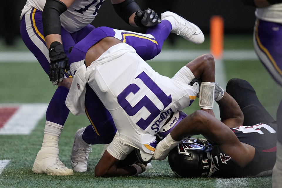 Atlanta Falcons defensive tackle Calais Campbell, right, sacks Minnesota Vikings quarterback Joshua Dobbs (15) in the end zone for a safety during the first half of an NFL football game, Sunday, Nov. 5, 2023, in Atlanta. (AP Photo/Mike Stewart)