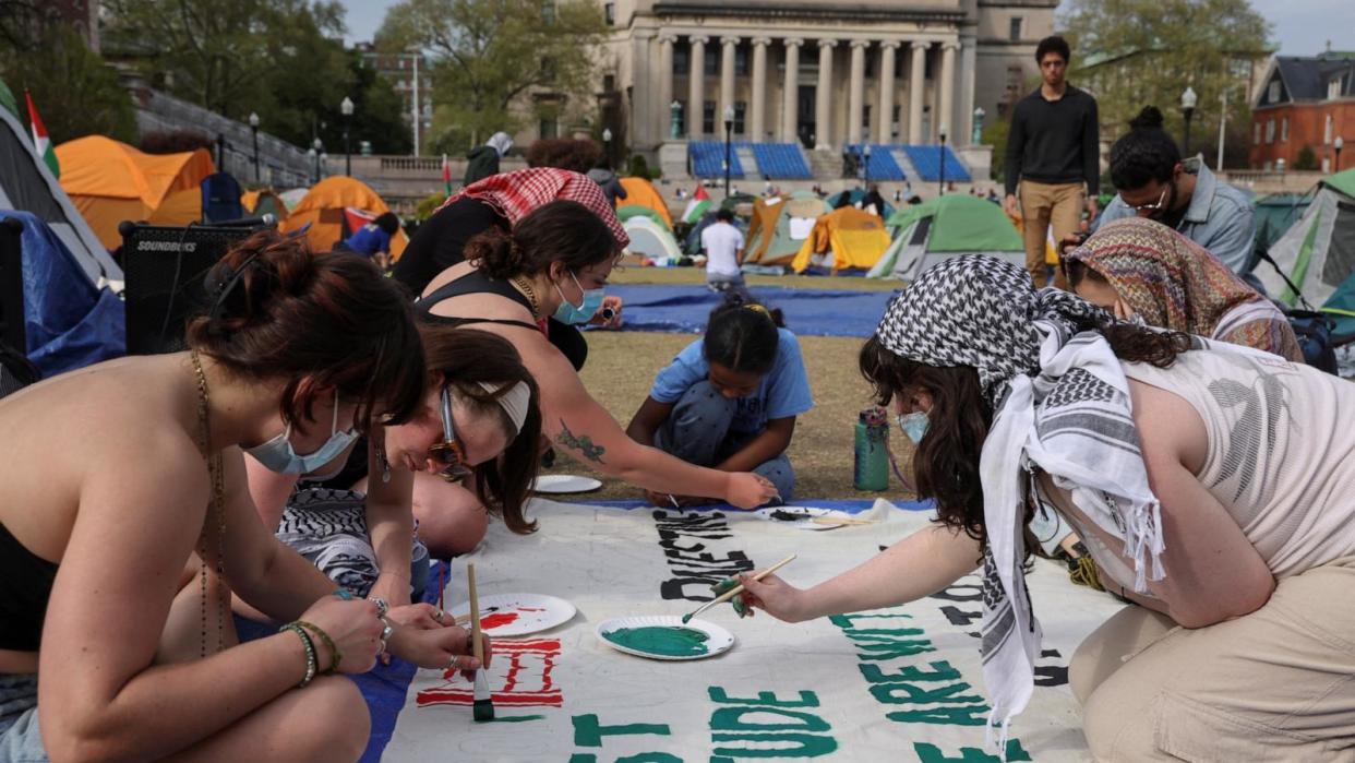 PHOTO: Students at Columbia University paint a response to a message written by Palestinians thanking students for their support as they continue to maintain a protest encampment on campus in support of Palestinians, in New York City, April 28, 2024. (Caitlin Ochs/Reuters)