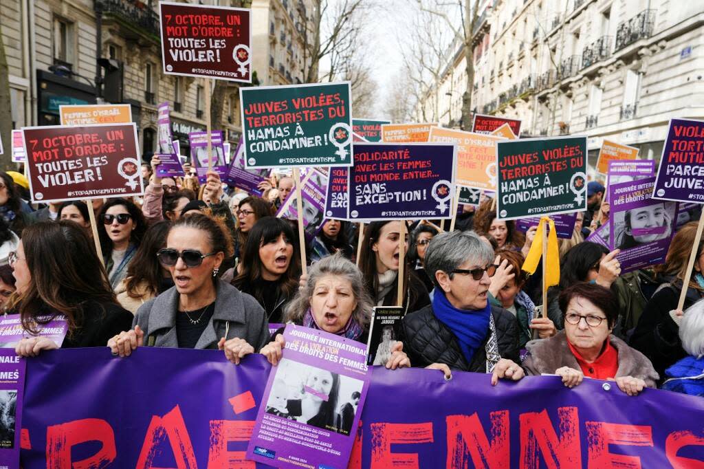 Des manifestants brandissent des pancartes « 7 octobre, un mot : violez-les tous ! », « Juifs violés, terroristes du Hamas, condamnés » et « Solidarité avec les femmes du monde entier, sans exception ! » lors d’une marche dans le cadre de la Journée internationale des droits des femmes, à Paris, le 8 mars 2024. 