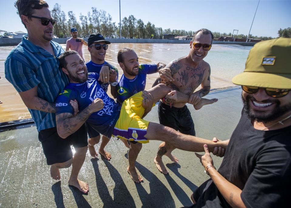 Friends prepare to throw 2015 WSL World Champion Adriano de Souza.