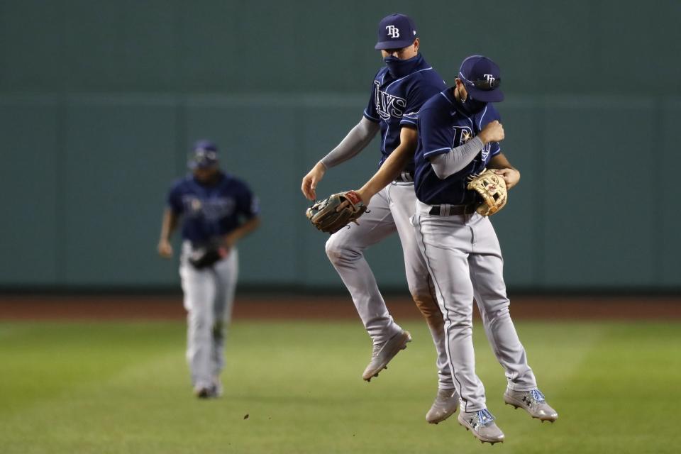 Tampa Bay Rays' Brandon Lowe, right, and Willy Adames celebrate after defeating the Boston Red Sox during a baseball game, Thursday, Aug. 13, 2020, in Boston. (AP Photo/Michael Dwyer)