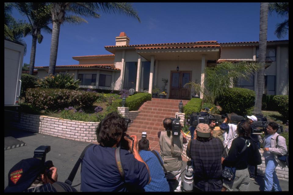 Photographers swarm the entrance of the home where 39 followers of cult leader Marshall Applewhite died in March 1997. The home has since been demolished.