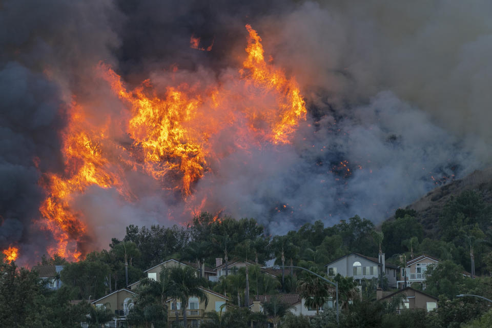 Flames rise near homes during the Blue Ridge fire on Oct. 27 in Chino Hills, California. (Photo: David McNew via Getty Images)
