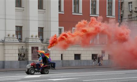 Gay rights activists drive an all-terrain vehicle (ATV) as they take part at an LGBT community rally in central Moscow, Russia, May 30, 2015. REUTERS/Maxim Shemetov