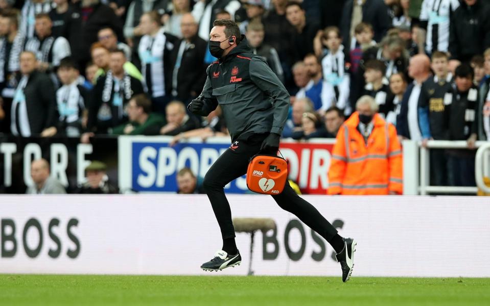 A member of the Newcastle medical team runs with a defibrillator after a fan is taken ill in the stand - Getty