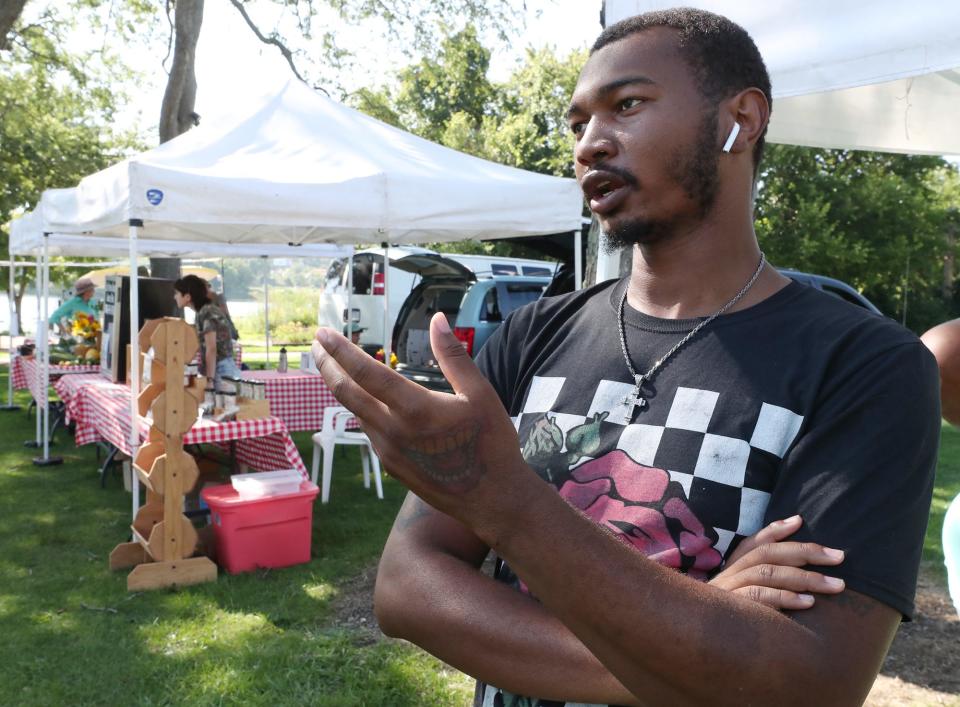 Carlin, 26, a resident of the Summit Lake neighborhood, talks about his experiences with gun violence as he shops at a farmers market. "Daytime, nighttime, it doesn't matter. Whatever time of the day, you'll always hear gunshots," he says.