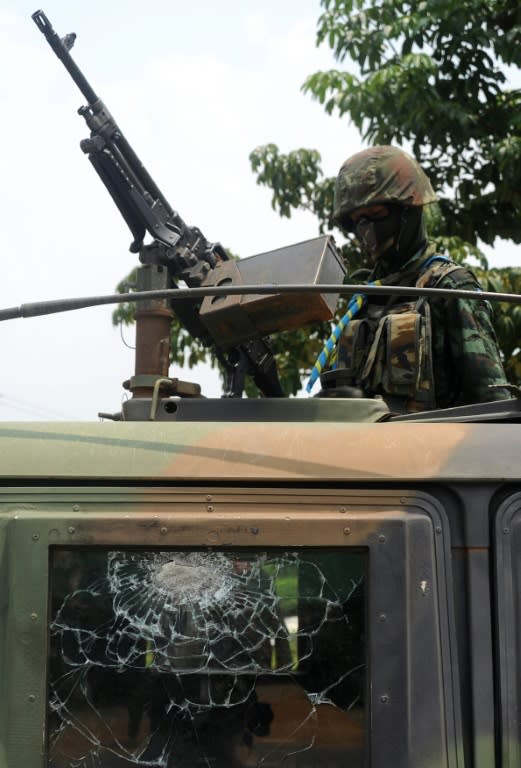 A Thai soldier stands guard on a damaged vehicle following a blast from a roadside bomb planted by suspected separatist militants, in restive southern province of Narathiwat, on October 8, 2015