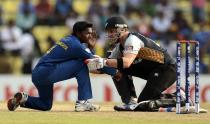 Sri Lanka's Akila Dhananjaya is helped by New Zealand's Brendon McCullum (R) after being hit in the face by the ball during the Twenty20 World Cup Super 8 match at Pallekele in Sri Lanka September 27, 2012. REUTERS/Philip Brown (SRI LANKA - Tags: SPORT CRICKET)