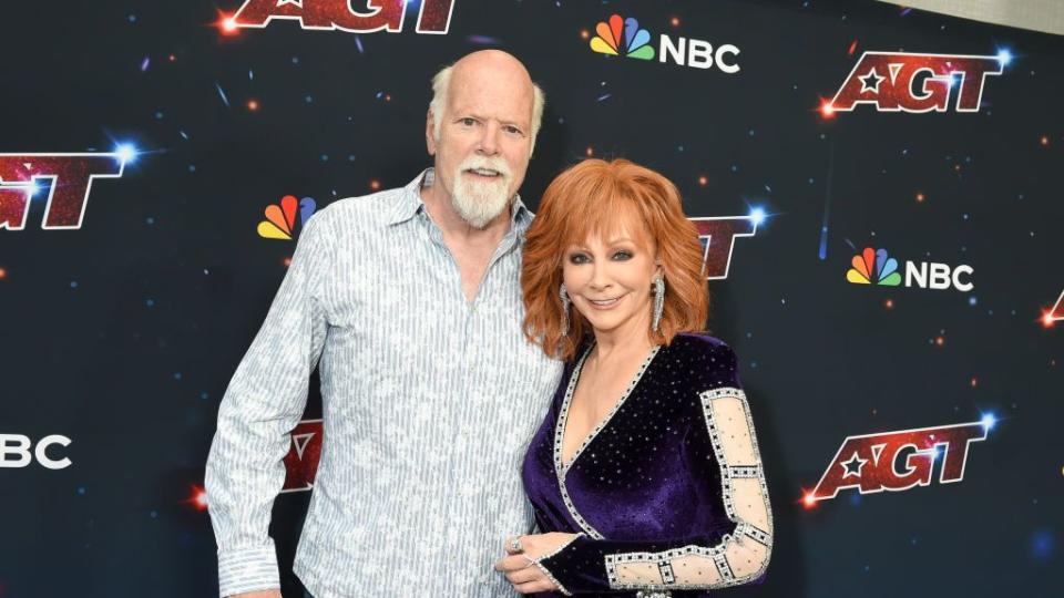 reba mcentire and rex linn embracing and smiling for a red carpet photo