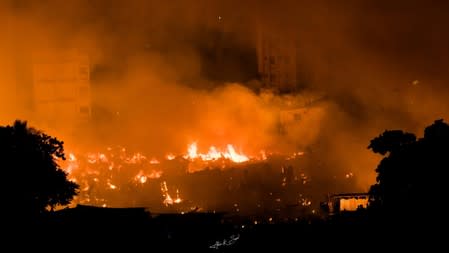 Flames engulf a slum after a fire broke out in Dhaka