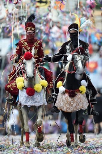 Revellers on horseback take part in a traditional carnival parade in Bonfim, Minas Gerais state, southeastern Brazil, on March 3, 2019. Dressed in hand-embroidered velvet costumes, people ride through the town with confetti and streamers in a tradition that dates back to the 18th century, to commemorate the war between the Moors and Christians