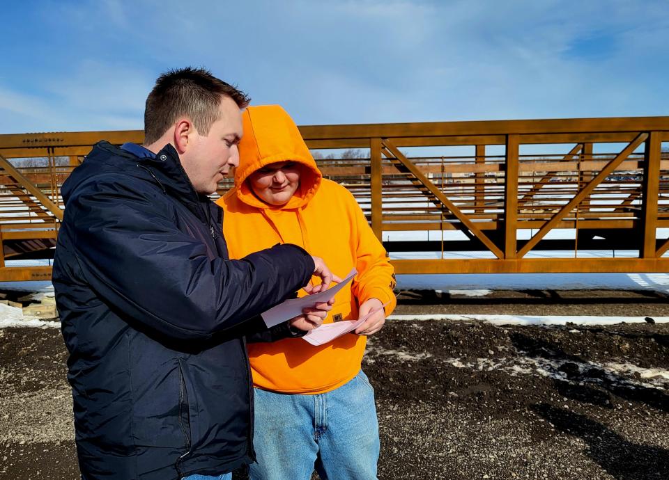 Port Huron Engineering Manager Brent Moore, left, goes over plans for the Black River Canal bridge, waiting placement behind them, with a local high school student on Thursday, March 16, 2023.